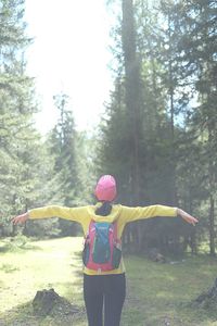 Rear view of woman standing in forest