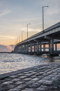 Bridge over river against sky during sunset