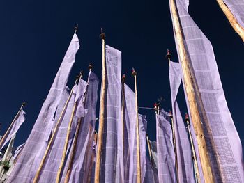 Low angle view of flags against clear sky