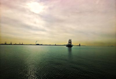 View of bridge over sea against cloudy sky
