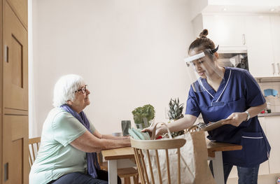 Home carer helping senior woman at home