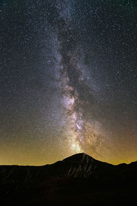 Scenic view of mountains against sky at night