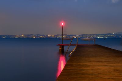 Pier over sea against sky at night