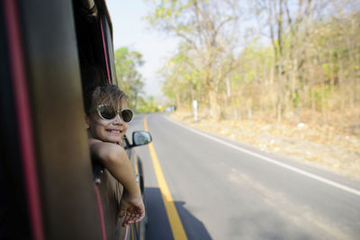 Girl leaning on vehicle window