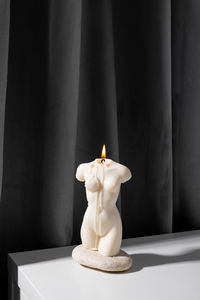 Close-up of burning candle on table