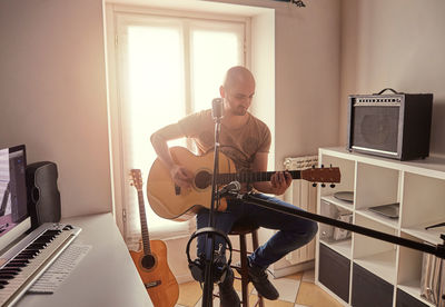 Mature man playing guitar at studio