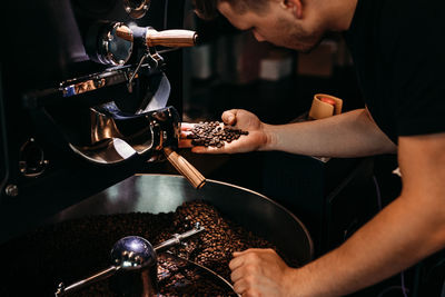 Side view of young man working in cafe