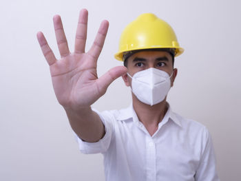 Portrait of man wearing mask against white background