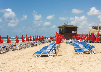 Side view of sun loungers in row on beach