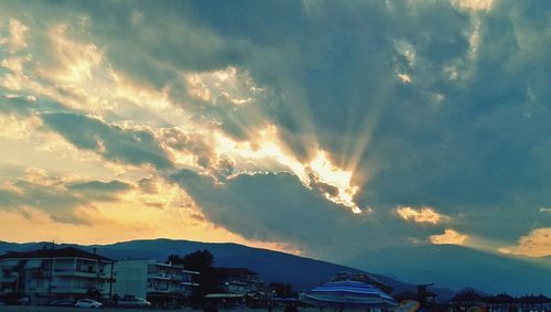 Scenic view of mountains against cloudy sky at sunset