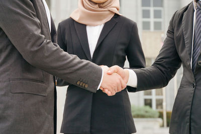 Midsection of couple holding hands