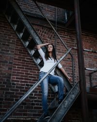 Low angle view of woman sitting on staircase