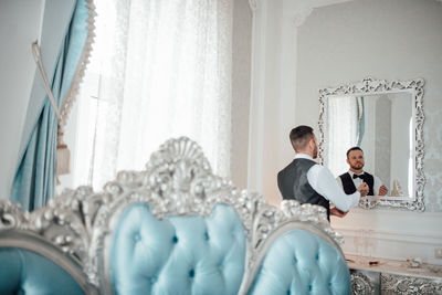 Man and woman sitting by window at home