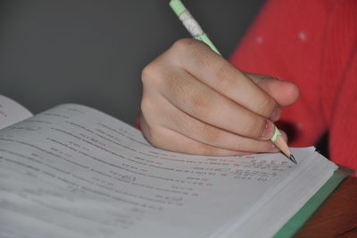 Close-up of hand holding book with text