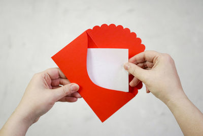 Close-up of hand holding red paper