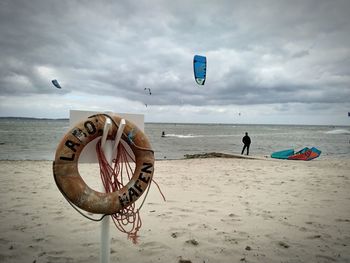 Deck chairs on beach against sky