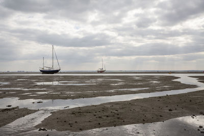 Fisherman boats stuck on the beach in low tide period in leigh-on-sea, uk.