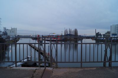 Pier over river against sky in city