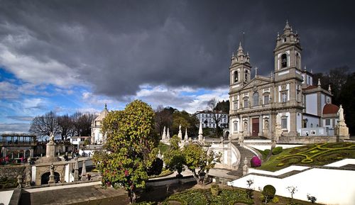 Buildings in city against cloudy sky