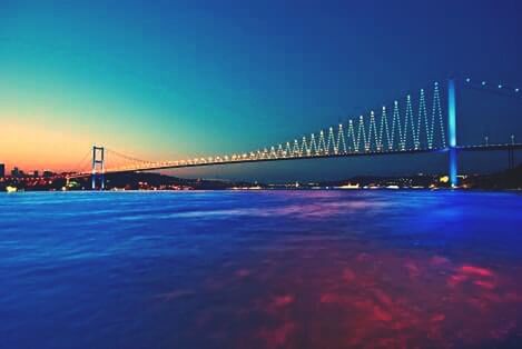 blue, illuminated, water, connection, built structure, architecture, clear sky, bridge - man made structure, waterfront, copy space, night, sea, bridge, river, engineering, city, suspension bridge, sky, dusk, mid distance