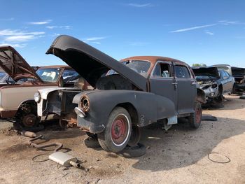 Abandoned car against sky