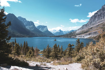 Scenic view of lake by snowcapped mountains against sky