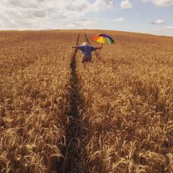Scenic view of field against cloudy sky