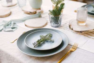 Blue plates, gold cutlery, a spruce branch on a plate. festive christmas winter dinner or family