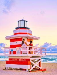 Lighthouse by sea against sky