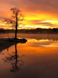 Scenic view of lake against orange sky