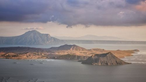 Scenic view of sea and mountains against sky