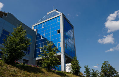 Low angle view of modern building against blue sky