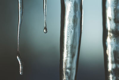 Close-up of icicles hanging against sky