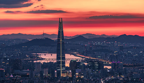 High angle view of illuminated city against sky at sunset