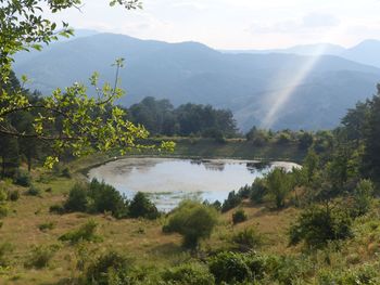 Scenic view of lake and mountains against sky