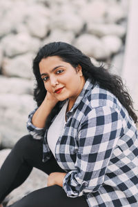 Street portrait of an indian girl in a plaid shirt outdoors