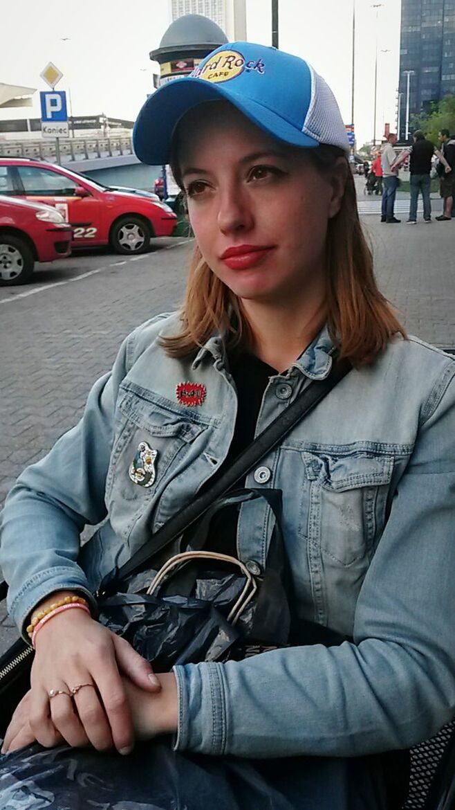 PORTRAIT OF YOUNG WOMAN SITTING ON STREET