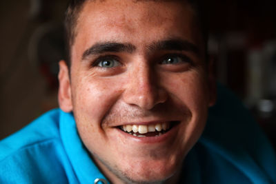 20s smiling man. closeup portrait of a happy young man smiling on blurred background. face young man 