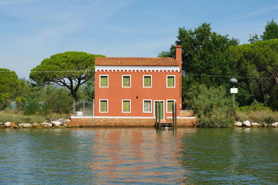 Building by river against sky