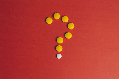 High angle view of candies against red background