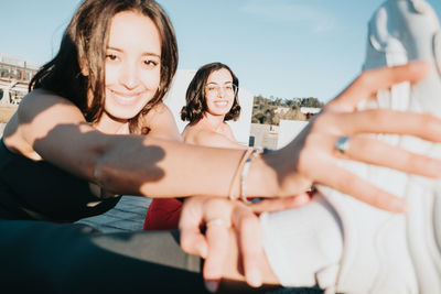 Portrait of smiling young woman holding hands