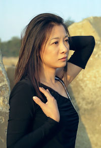 Woman wearing black dress looking away at farm