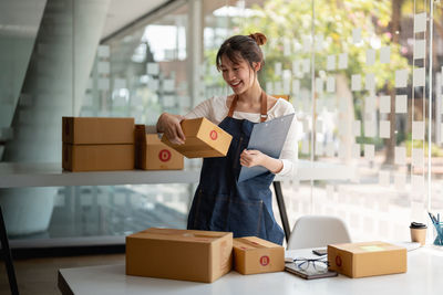 Portrait of young woman holding box