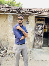 Portrait of young man wearing sunglasses standing outdoors