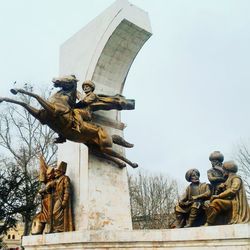 Statue in city against clear sky