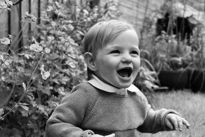 Close-up of cute baby boy with mouth open in yard