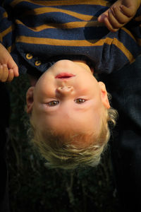 Close-up portrait of cute baby boy hanging upside down