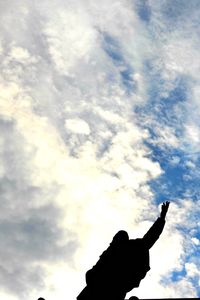 Woman with arms raised against clear sky