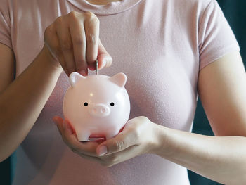 Midsection of woman holding piggy bank