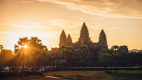 View of trees and buildings against sky during sunset